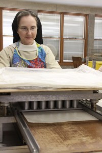 Sr. Anne cutting breads on the large cutter